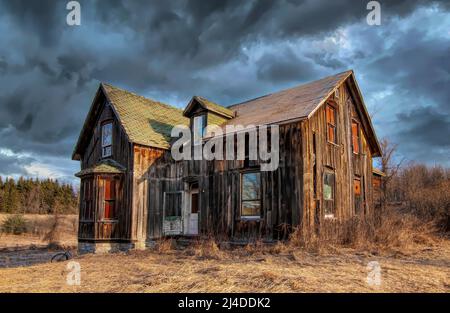 Ein altes, verlassene, gruselig aussehendes Bauernhaus im Winter auf einem Bauernhof im ländlichen Kanada Stockfoto