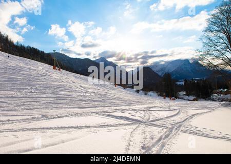 Wintertag im österreichischen Alpinskigebiet mit bewölktem Himmel und strahlend weißem Schnee. Steiermark, Oberösterreich Stockfoto