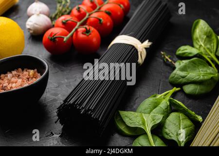 Tintenfisch Tinte schwarz getönte Twirl von rohen Tagliatelle Set, auf schwarzem dunklen Stein Tischhintergrund Stockfoto