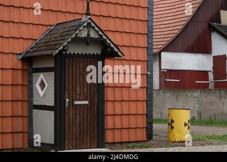 Salzgitter, Deutschland. 14. April 2022. Ein Fass mit einem bemalten Atomschild steht als Protestaktion neben einem Hauseingang im Dorf Bleckenstedt bei Salzgitter, nahe dem Konrad-Schacht. Im bereits zugelassenen Endlager Schacht Konrad sollen niedrig- bis mittelradioaktive Abfälle gelagert werden. Kredit: Mia Bucher/dpa/Alamy Live Nachrichten Stockfoto