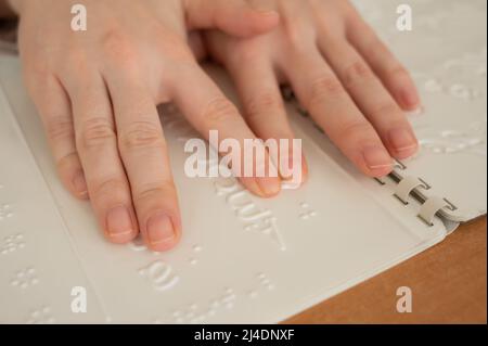 Eine Frau lernt das Braillealphabet mit einem Decoder. Stockfoto
