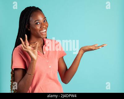 Afroamerikanische Frau mit umgesteldeter Palme. Sprecher posieren, Ihr Produkt in der Handfläche zu halten. Stockfoto