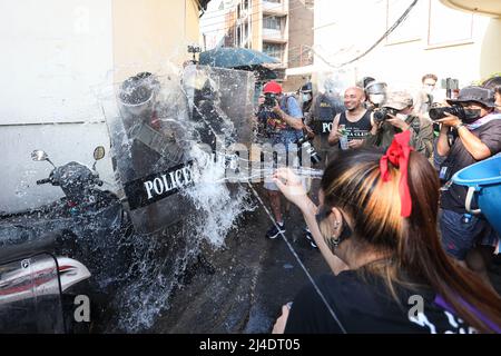 Bangkok, Thailand. 13. April 2022. Die Bereitschaftspolizei, die einen Schild hält, wacht um das Demokratiedenkmal herum und wurde von den Demonstranten mit Wasser bespritzt. (Foto: Adirach Toumlamoon/Pacific Press) Quelle: Pacific Press Media Production Corp./Alamy Live News Stockfoto