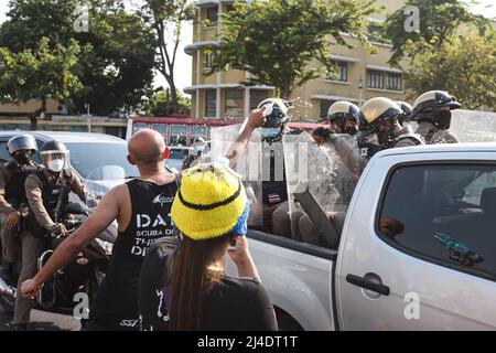 Bangkok, Thailand. 13. April 2022. Die Bereitschaftspolizei, die einen Schild hält, wacht um das Demokratiedenkmal herum und wurde von den Demonstranten mit Wasser bespritzt. (Foto: Adirach Toumlamoon/Pacific Press) Quelle: Pacific Press Media Production Corp./Alamy Live News Stockfoto