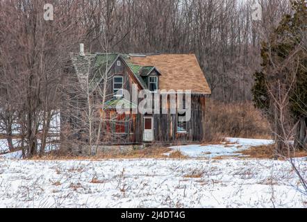 Ein altes, verlassene, gruselig aussehendes Bauernhaus im Winter auf einem Bauernhof im ländlichen Kanada Stockfoto