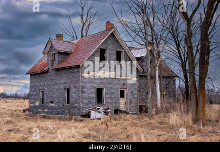 Ein altes, verlassene, gruselig aussehendes Bauernhaus im Winter auf einem Bauernhof im ländlichen Kanada Stockfoto