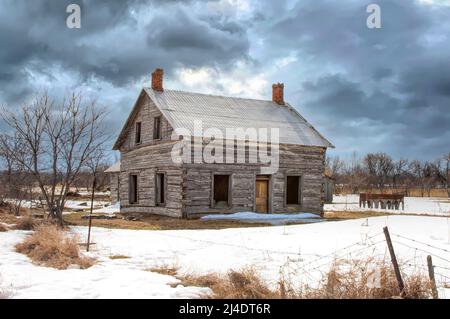 Ein altes, verlassene, gruselig aussehendes Bauernhaus im Winter auf einem Bauernhof im ländlichen Kanada Stockfoto