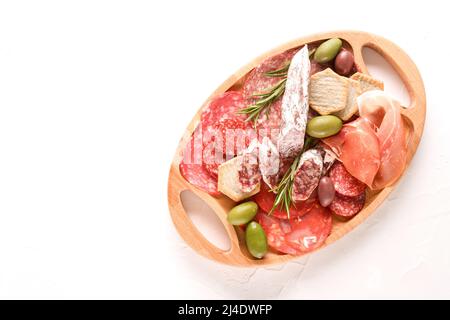 Holzkochplatte mit verschiedenen Wurstsorten - Salami, Bresaola, Proscuitto serviert mit Oliven und Crackern. Traditionelle italienische GegenVergangenheit Stockfoto