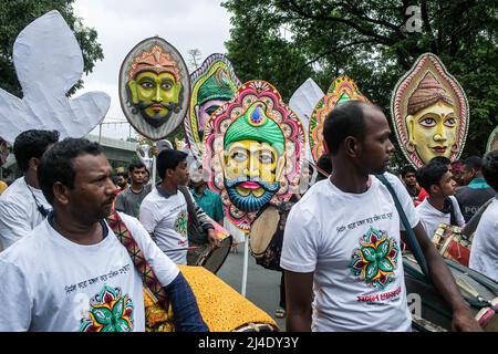 Dhaka, Bangladesch. 14. April 2022. Menschen tragen Masken bei einer Kundgebung, um Pohela Boishakh, den ersten Tag des bengalischen Neujahrs, in Dhaka zu feiern. Tausende von Menschen aus Bangladesch feiern den ersten Tag des bengalischen Neujahrs oder Pohela Boishakh, mit verschiedenen bunten Kundgebungen, kulturellen Programmen mit traditionellem Tanz und Musik, wurde dieses bengalische Jahr während des Regimes von Kaiser Akbar eingeführt, um die Einnahmeerhebung im 16.. Jahrhundert zu erleichtern. Kredit: SOPA Images Limited/Alamy Live Nachrichten Stockfoto