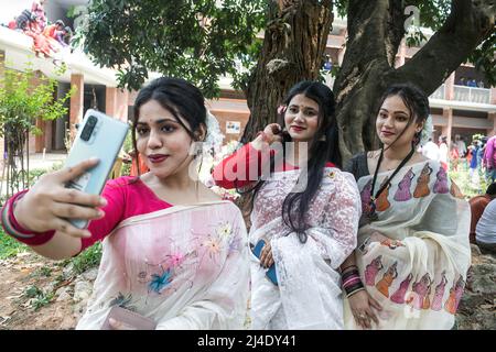 Dhaka, Bangladesch. 14. April 2022. Junge Damen machen ein Selfie, um den ersten Tag des bengalischen Neujahrs oder Pohela Boishakh in Dhaka zu feiern. Tausende von Menschen aus Bangladesch feiern den ersten Tag des bengalischen Neujahrs oder Pohela Boishakh, mit verschiedenen bunten Kundgebungen, kulturellen Programmen mit traditionellem Tanz und Musik, wurde dieses bengalische Jahr während des Regimes von Kaiser Akbar eingeführt, um die Einnahmeerhebung im 16.. Jahrhundert zu erleichtern. Kredit: SOPA Images Limited/Alamy Live Nachrichten Stockfoto