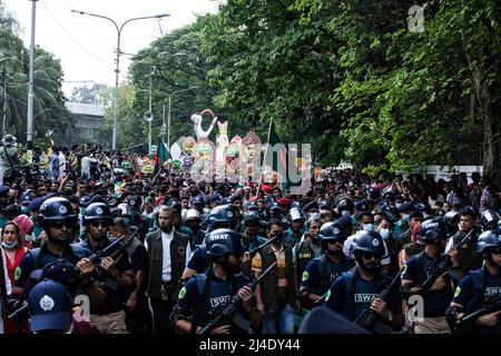 Dhaka, Bangladesch. 14. April 2022. Menschen zusammen mit der Polizei gesehen während einer Kundgebung, um das bengalische Neujahr oder Pohela Boishakh in Dhaka zu feiern. Tausende von Menschen aus Bangladesch feiern den ersten Tag des bengalischen Neujahrs oder Pohela Boishakh, mit verschiedenen bunten Kundgebungen, kulturellen Programmen mit traditionellem Tanz und Musik, wurde dieses bengalische Jahr während des Regimes von Kaiser Akbar eingeführt, um die Einnahmeerhebung im 16.. Jahrhundert zu erleichtern. Kredit: SOPA Images Limited/Alamy Live Nachrichten Stockfoto