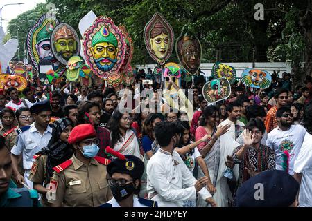 Dhaka, Bangladesch. 14. April 2022. Menschen tragen Masken bei einer Kundgebung, um Pohela Boishakh, den ersten Tag des bengalischen Neujahrs, in Dhaka zu feiern. Tausende von Menschen aus Bangladesch feiern den ersten Tag des bengalischen Neujahrs oder Pohela Boishakh, mit verschiedenen bunten Kundgebungen, kulturellen Programmen mit traditionellem Tanz und Musik, wurde dieses bengalische Jahr während des Regimes von Kaiser Akbar eingeführt, um die Einnahmeerhebung im 16.. Jahrhundert zu erleichtern. (Foto: Sazzad Hossain/SOPA Images/Sipa USA) Quelle: SIPA USA/Alamy Live News Stockfoto