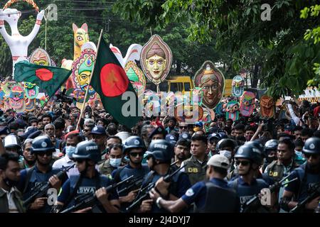 Dhaka, Bangladesch. 14. April 2022. Menschen tragen Masken bei einer Kundgebung, um Pohela Boishakh, den ersten Tag des bengalischen Neujahrs, in Dhaka zu feiern. Tausende von Menschen aus Bangladesch feiern den ersten Tag des bengalischen Neujahrs oder Pohela Boishakh, mit verschiedenen bunten Kundgebungen, kulturellen Programmen mit traditionellem Tanz und Musik, wurde dieses bengalische Jahr während des Regimes von Kaiser Akbar eingeführt, um die Einnahmeerhebung im 16.. Jahrhundert zu erleichtern. (Foto: Sazzad Hossain/SOPA Images/Sipa USA) Quelle: SIPA USA/Alamy Live News Stockfoto