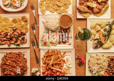 Karibische Gerichte mit Fleischeintöpfen mit Reis, Tostones und Kochbananen, maurischem Reis, Hühnerfleisch und Hackfleisch Stockfoto