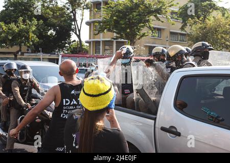 Bangkok, Thailand. 13. April 2022. Die Bereitschaftspolizei, die einen Schild hält, wacht um das Demokratiedenkmal herum und wurde von den Demonstranten mit Wasser bespritzt. (Bild: © Adirach Toumlamoon/Pacific Press via ZUMA Press Wire) Stockfoto