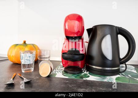 Kapsel-Kaffeemaschine neben robusten schwarzen eine auf einer dunkelgrauen Holz-Arbeitsplatte Stockfoto