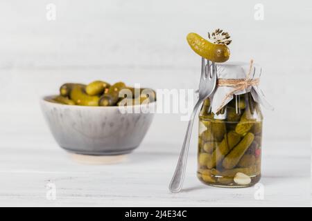 Eingelegte Gurken, Gewürze und Knoblauch auf weißem Holztisch konservieren Stockfoto