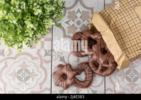 Kekse zum Valentinstag. Mit Schokolade beschichtete Lebkuchenkekse. Aus dem Beutel auf dem Tisch verschüttet. Stockfoto