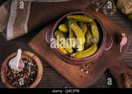 Teller mit Gurken, eingelegten Gurken auf rustikalem Holzhintergrund Stockfoto