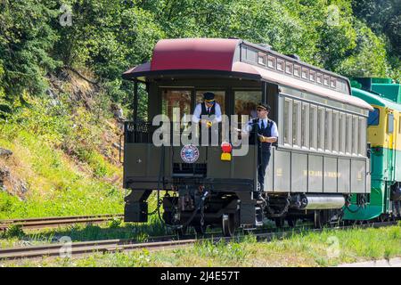 Bahnleiter führen Einen historischen Schienenwagen, der von Einem Diesel-Elektrozug angetrieben wird 93 White Pass Yukon Route Railway Shunted Tourist Train Passenger TR Stockfoto