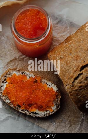 Sandwiches mit lachsrotem Kaviar auf Holzgrund Stockfoto