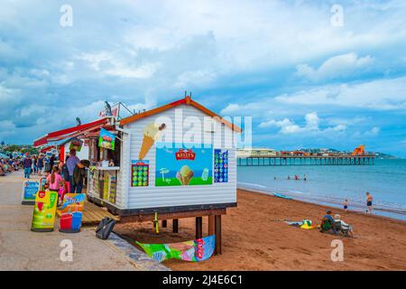 Blick auf den Paignton Beach - Ein langer Pier ragt von diesem beliebten Sandstrand zum Schwimmen und in der Nähe Cafés und Arkaden. Stockfoto