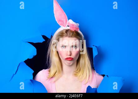 Frohe Ostern. Hase Mädchen in Kaninchenohren Blick durch Papierloch. Frühlingsangebot. Rabatt Stockfoto