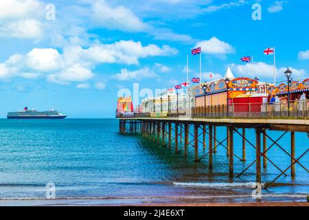 Blick auf den Paignton Beach - Ein langer Pier ragt von diesem beliebten Sandstrand zum Schwimmen und in der Nähe Cafés und Arkaden. Stockfoto