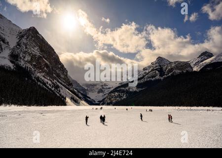 Menschen, die auf einem gefrorenen Lake Louise im Banff National Park, Alberta, Kanada, spazieren gehen Stockfoto