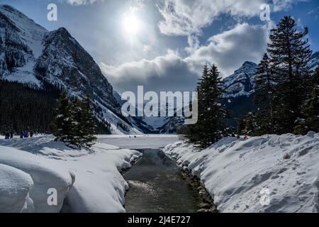 Menschen, die auf einem gefrorenen Lake Louise im Banff National Park, Alberta, Kanada, spazieren gehen Stockfoto