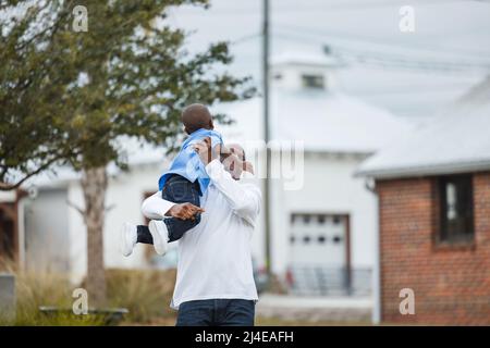 Ein kleiner Junge im Vorschulalter wird von seinem Vater abgeholt Stockfoto