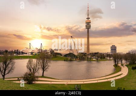 Olympiapark in München Deutschland mit einem Teich und dem hohen Turm bei Sonnenuntergang Stockfoto