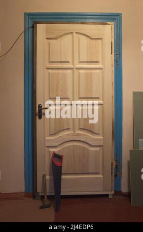 Reparatur im alten Haus. Austauschen der Klappen. Neue Holztüren werden anstelle von alten eingebaut. Stockfoto