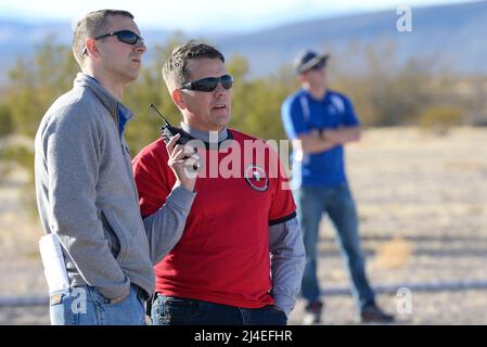 Casey Kleisinger, ein Mitglied des Teams von Robins Air Force Base, Ga. und Kapitän John Walton, 2016 Air Force Research Laboratory Commanders Challenge Program Execution Officer, hören Radio Kommunikation während der Veranstaltung an der Nevada National Security Website, Las Vegas, NV., Dez. 13, 2016. Mannschaften wurden sechs Monaten eine komplette Zähler - Unmanned Aerial Systems in Base Defense zu Hilfe zu entwickeln. Robins' system ist eine vielschichtige integriertes System verwendet ein Radar und Kamera System für den Nachweis und die Identifizierung. Es verwendet auch ein Hunter killer Drohnen für die Überwachung des Fernmeldeverkehrs und Wasserwerfer für Sh Stockfoto