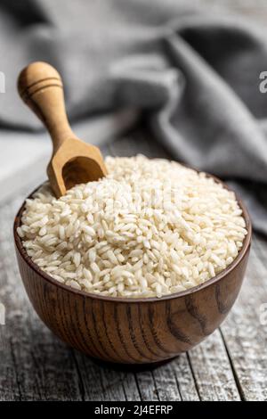 Ungekochte Carnaroli Risotto Reis in einer Schüssel auf einem Holztisch. Stockfoto