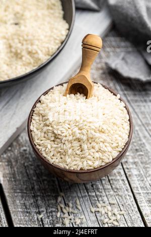 Ungekochte Carnaroli Risotto Reis in einer Schüssel auf einem Holztisch. Stockfoto