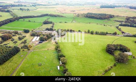 Luftdrohnenansicht der St Oswalds Farm und Kirche und Heavenfield an der römischen Mauer in Northumberland Stockfoto