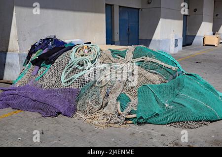 Ein unordentlicher Haufen von Fischernetzen am Rande des Strandes in Estepona in Spanien Stockfoto