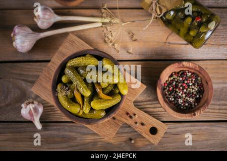 Eingelegte Gurken, Gewürze und Knoblauch auf Holztisch konservieren Stockfoto