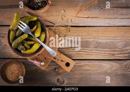 Eingelegte Gurken, Gewürze und Knoblauch auf Holztisch konservieren Stockfoto