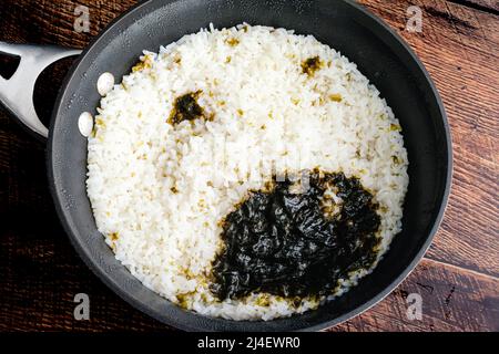 Sushi-Reis, der mit einem Nori-Blatt gekocht wurde: Frischer Sushi-Reis in einem Topf, der mit einem Stück Algen gekocht wurde Stockfoto