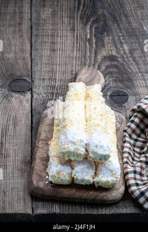 Schuppige süße Brötchen mit Creme auf Holztisch Stockfoto