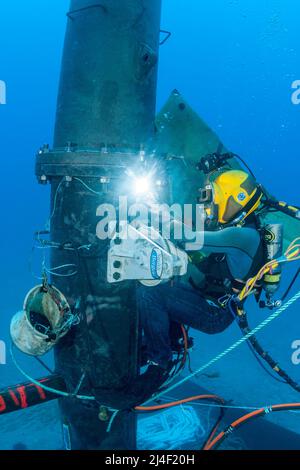 Ein kommerzieller Hartmütstaucher (MR) schweißen eine massive Wellenenergie-Boje vor Kaneoho Bay, Oahu. Die 40-kW-Versuchsboje, nutzt die Bobing-Bewegung von Stockfoto