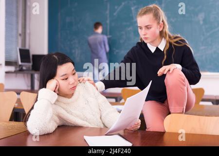 Teen weibliche Student Unterstützung verärgert chinesisches Mädchen im Klassenzimmer Stockfoto