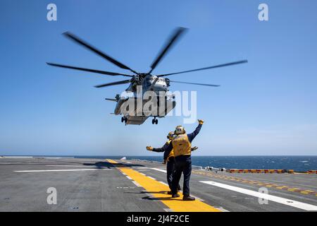 220413-N-NY430-2098 PAZIFISCHER OZEAN (13. April 2022) – Aviation Boatswain’s Mate (Handling) 3. Class Jonathan Walker, rechts, Und Airman Kory Vogel leitet einen CH-53E Superhengst, der dem Marine Heavy Helicopter Squadron (HMH) 462 zugewiesen wurde, als er vom Flugdeck des Amphibious Assault Ship USS Makin Island (LHD 8) im April 13 abhebt. Die Kameraden von Aviation Boatswain lenken die Bewegung und das Auffinden von Flugzeugen an Land und im Wasser. Makin Island führt derzeit Routineoperationen in der US 3.-Flotte durch. (USA Navy Foto von Mass Communication Specialist 2. Klasse Kristopher S. Haley) Stockfoto