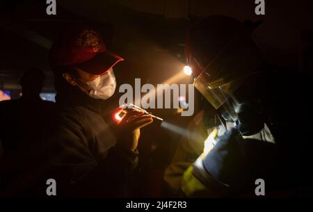 SÜDLICHER OZEAN (11. April 2022) – Hull Maintenance Technician 1. Klasse Aliyah Mangan, aus Englewood, New Jersey, überprüft den in sich geschlossenen Atemgeräteinstrug des zivilen Mariners Claude VanDusen aus Guam, beide dem U-Boot-Tender USS Frank Cable der Emory S Land-Klasse (AS 40) zugeordnet, Während einer Schadenskontrollübung auf See, April 11. Frank Cable ist derzeit auf Patrouille, die Expeditions-Wartung und Logistik zur Unterstützung der nationalen Sicherheit im US-7.-Flottenbereich durchführt. (USA Navy Foto von Mass Communication 1. Klasse Charlotte C. Ol Stockfoto