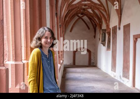 Mainz, Deutschland. 09. April 2022. Die 29-jährige Klimaschutzaktivistin Edith Wittenbrink steht vor einem Gottesdienst der Gruppe "Christen 4 Zukunft" im Kreuzgang der Kirche St. Stephan. Die im Stil des "Fridays for future" gegründete Gruppe ruft evangelische Landeskirchen und Diözesen dazu auf, ihr Engagement für den Klimaschutz zu verstärken. (To dpa: 'Klimaschützer bringen Kirchen zum Gebet') Quelle: Peter Zschunke/dpa-Zentralbild/dpa/Alamy Live News Stockfoto