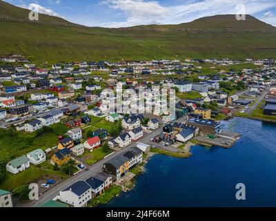 Wunderschöner Blick aus der Vogelperspektive auf die Stadt Klaksvik auf den Fareo-Inseln mit ihren bunten Häusern und dem atemberaubenden Kanal und Blick auf den majestätischen Kunoy Park Stockfoto