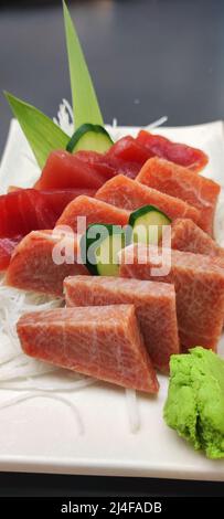 Die erstklassigen Sashimi mit frischen japanischen Meeresfrüchten in einer schwarzen japanischen Schüssel mit Miso-Suppe und rohen Meeresfrüchten Stockfoto
