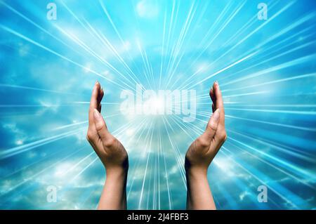 Frau Hände um ein spirituelles göttliches Licht Stockfoto